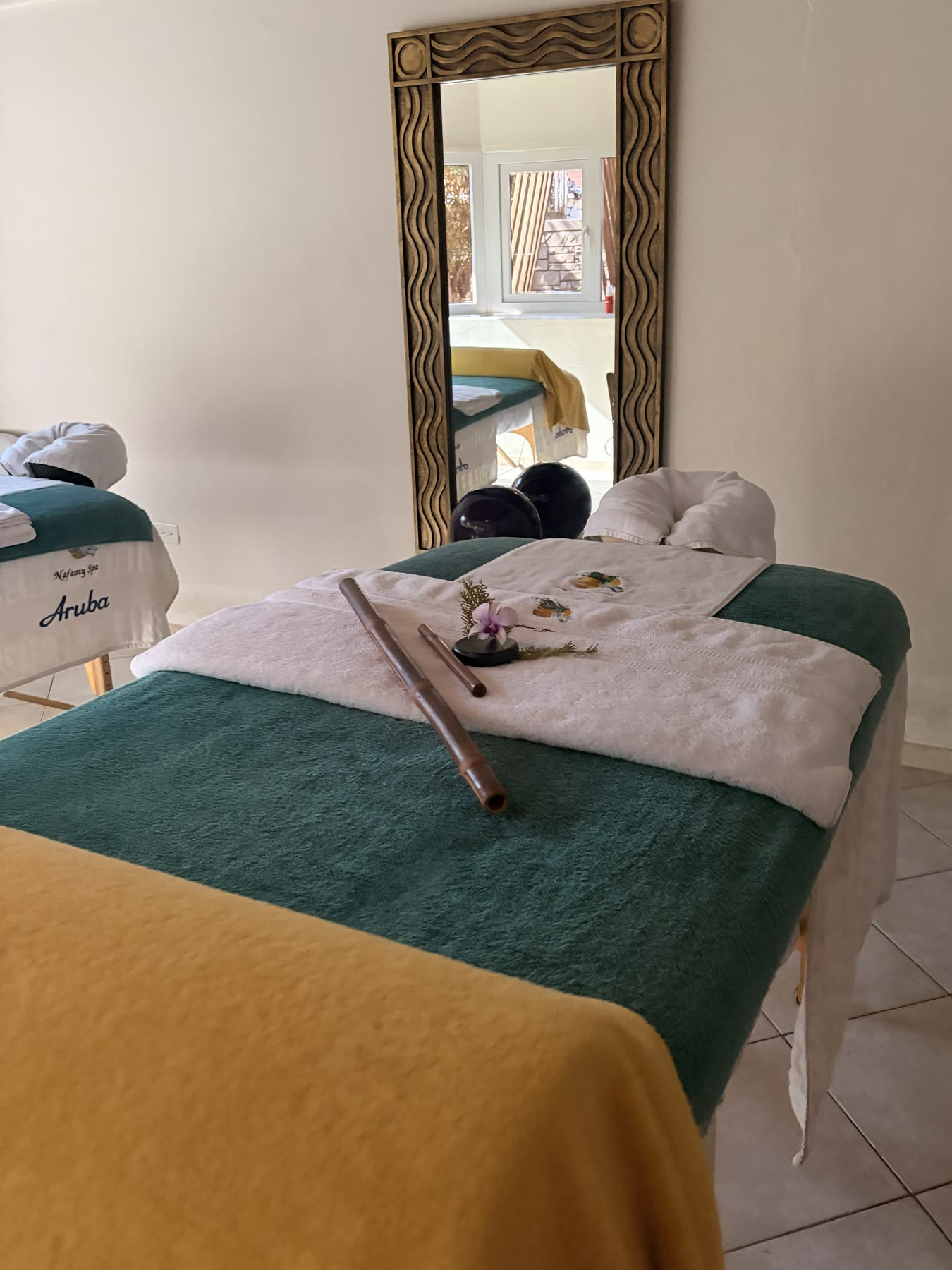 Massage table dressed with fresh linens and an orchid, ready for a guest