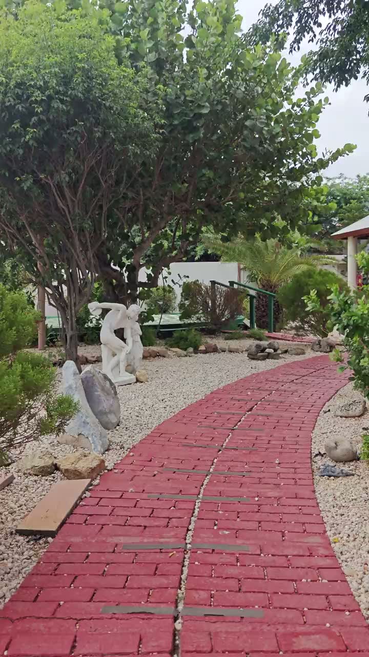 The gardens at Nafanny Spa — the thatched gazebo and hammock, Buddha statues among the planting, brick pathways and native cacti