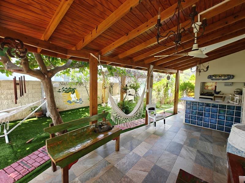 Wide view of the reception area with rattan seating and hanging plants